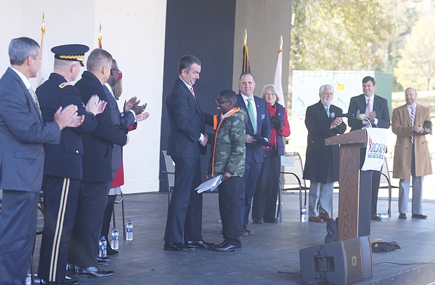 Armistice Day: Gov. Ralph S. Northam congratulates Martene Whiting Jr., 13, a seventh-grader at Tabb Middle School in Yorktown, after he read his winning essay on “What was the impact of World War I in Virginia?” during last Sunday’s Veterans Day ceremony at Dogwood Dell. The essay contest and ceremony was part of the state’s commemoration of the 100th anniversary of the end of World War I, known as Armistice Day. (Regina H. Boone/Richmond Free Press)