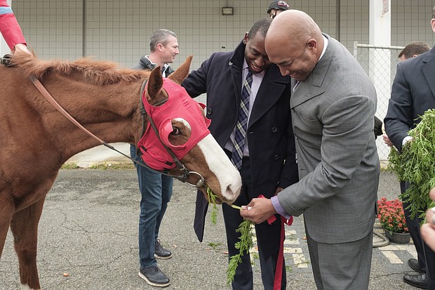 Mayor Levar M. Stoney, left, and City Councilman Michael J. Jones feed a racehorse at Wednesday’s groundbreaking for Rosie’s, a new off-track betting parlor at the former K-Mart building at 6807 Midlothian Turnpike in South Side.