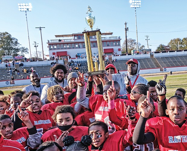 Players and coaches with the Richmond Parks and Recreation 2018 Champion Reid Ravens celebrate after defeating the Hotchkiss Eagles 18-0 in the 10U Peewee division last Saturday at City Stadium.