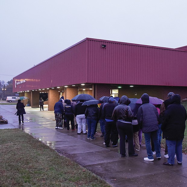 Thanksgiving comes early: Dozens of people wait in line in the rain last Thursday outside the Arthur Ashe Jr. Athletic Center in Richmond to receive boxed Thanksgiving meals. The Thanksgiving Harvest food program was sponsored by St. Paul’s Baptist Church and a coalition of Richmond area organizations. (Photos by Clement Britt)