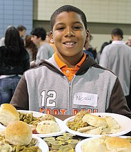 Volunteer Noah Crockett serves Thanksgiving meals at The Giving Heart Community Thanksgiving Feast in Downtown in 2010.