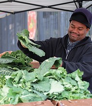 Timothy Christian, a fifth-generation vendor at the 17th Street Farmers’ Market, shows off fresh collard greens. Forced to leave the market during construction, he now sets up his stand outside nearby Main Street Station in Shockoe Bottom.