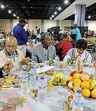 Giving thanks: Hundreds of people enjoyed a sumptuous dinner on Thanksgiving Day at The Giving Heart Community Thanksgiving Feast at the Greater Richmond Convention Center in Downtown. The annual event is free and draws hundreds of volunteers and contributors who provide fellowship and service to families and individuals sitting down for dinner. Among those enjoying the food are, top from left, Harry Howell, Henry Munford, Royal Munford, Mary Singh and Josephine Munford. Behind the scenes, volunteers are hard at work preparing plates with turkey and all the fixings. (Sandra Sellars/Richmond Free Press)