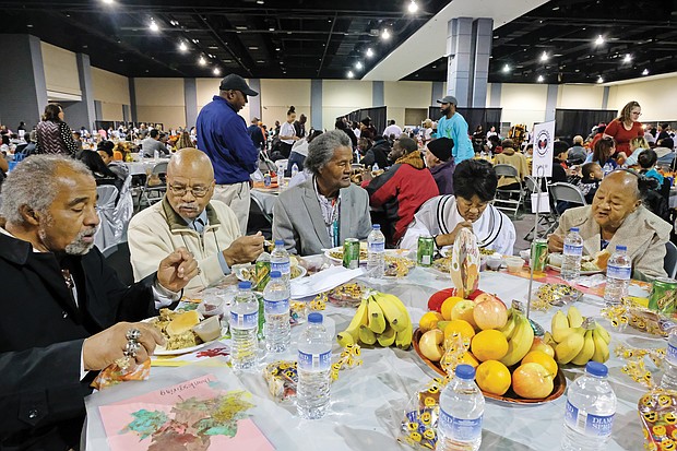 Giving thanks: Hundreds of people enjoyed a sumptuous dinner on Thanksgiving Day at The Giving Heart Community Thanksgiving Feast at the Greater Richmond Convention Center in Downtown. The annual event is free and draws hundreds of volunteers and contributors who provide fellowship and service to families and individuals sitting down for dinner. Among those enjoying the food are, top from left, Harry Howell, Henry Munford, Royal Munford, Mary Singh and Josephine Munford. Behind the scenes, volunteers are hard at work preparing plates with turkey and all the fixings. (Sandra Sellars/Richmond Free Press)