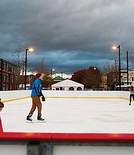 Krista Waddell, left, and her 5-year-old daughter, Aribella, get ready to join Ian Donselaar, 18, center, on RVA On Ice’s skating rink located at the 17th Street Farmers’ Market near Main Street Station. Sponsored by Capital One, the rink quietly opened just before Thanksgiving at its new location. It’s official opening will be Friday, Dec. 1. The rink will be open seven days a week before wrapping up the season on Monday, Jan. 21, Martin Luther King Day. “Rock the Rink” parties are scheduled for 8 to 10 p.m. Saturday nights in December and January. On most days, the rink and skate rental tent open at 3 p.m.; however, skating begins at 11 a.m. on Saturdays and Sundays. Details: (804) 234-3905 or https://enrichmond.org/17th-street-market/rva-on-ice. (Regina H. Boone/Richmond Free Press )