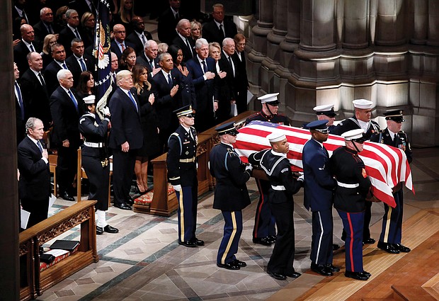 The flag-draped casket of former President George H.W. Bush is carried into Washington National Cathedral on Wednesday by military pallbearers past his son, left, former President George W. Bush, and in the pew at right, President Trump and First Lady Melania Trump; former President Barack Obama and Michelle Obama; former President Bill Clinton and Hillary Clinton; and former President Jimmy Carter and Rosalynn Carter.