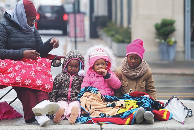 Waiting for Santa: Cheryl Brunson of Henrico and her three granddaughters are bundled up against the cold as they await the holiday floats and marching bands — and Santa — last Saturday at the 35th Annual Christmas Parade in Richmond. The youngsters, from left, are Maleah Atkinson and Lyric Dunlap, both 3, and Kha’mya Atkinson, 8. (Regina H. Boone/Richmond Free Press)