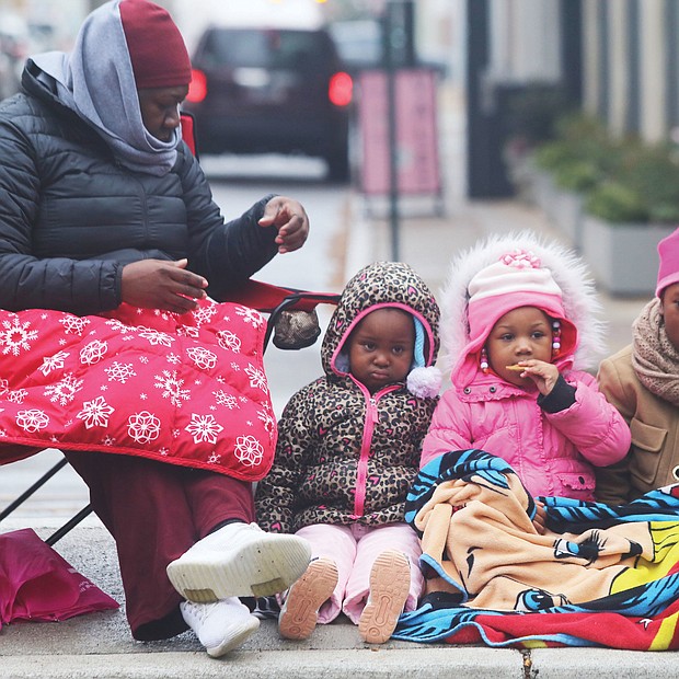 Waiting for Santa: Cheryl Brunson of Henrico and her three granddaughters are bundled up against the cold as they await the holiday floats and marching bands — and Santa — last Saturday at the 35th Annual Christmas Parade in Richmond. The youngsters, from left, are Maleah Atkinson and Lyric Dunlap, both 3, and Kha’mya Atkinson, 8. (Regina H. Boone/Richmond Free Press)
