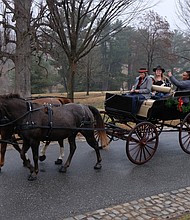 Old-fashioned Christmas: Visitors to Maymont embraced the holiday spirit last Sunday with the park’s annual Old-fashioned Christmas celebration. Yolanda Smith and Brittany Powell take a selfie during a carriage ride around the grounds. The Gilded-Age mansion will be decked out for holiday tours through Jan. 6  (Sandra Sellars/Richmond Free Press)