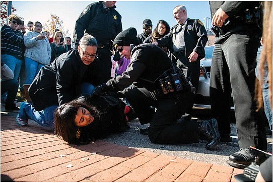 A member of CityWell United Methodist Church in Durham, N.C., is arrested on Nov. 23 after she and other members and supporters accompanied Samuel Oliver-Bruno, an undocumented Mexican national who had taken sanctuary in the church, to an appointment with immigration officials.