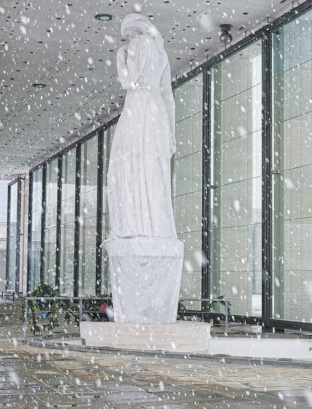 Brrrrr! The first snowfall of the season last Sunday resulted in people heading outdoors in the cold to clear snowy walkways and parking spots so that people and cars could safely maneuver. The marble statue at the Virginia War Memorial stands in contrast to the falling snowflakes. (Regina H. Boone/Richmond Free Press)