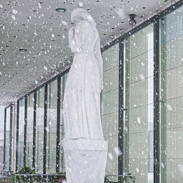 Brrrrr! The first snowfall of the season last Sunday resulted in people heading outdoors in the cold to clear snowy walkways and parking spots so that people and cars could safely maneuver. The marble statue at the Virginia War Memorial stands in contrast to the falling snowflakes. (Regina H. Boone/Richmond Free Press)