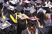 The 300 fall graduates hood one another during the ceremony and celebrated by decorating their mortar boards with flowers and other expressions.