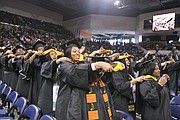 The 300 fall graduates hood one another during the ceremony and celebrated by decorating their mortar boards with flowers and other expressions.