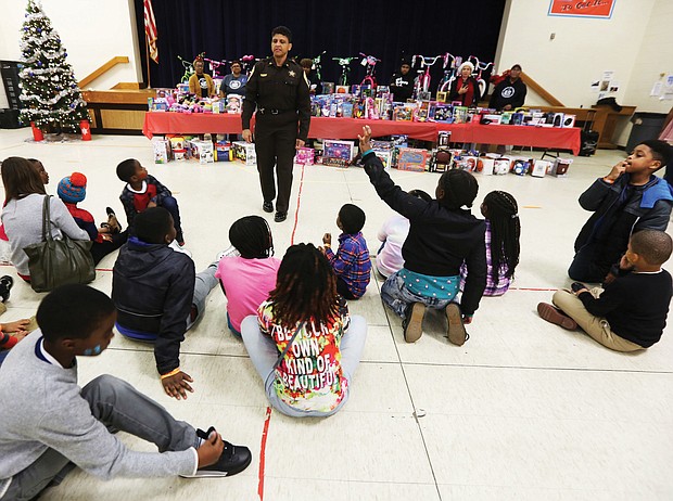 Toys, toys, toys! Richmond Sheriff Antionette V. Irving talks with youngsters at the “No Child Without a Toy” event last Friday at Woodville Elementary School in the East End. The city Sheriff’s Office is partnering with St. Paul’s Baptist Church and AFOI, Assisting Families of Inmates, to ensure that youngsters have gifts during this holiday season. The youngsters in AFOI’s “Milk and Cookies” mentoring program enjoyed face painting, decorating ornaments and other activities before the toys were distributed. The mentoring program is active in several Richmond elementary schools, including Woodville, Chimborazo and Swansboro. (Regina H. Boone/Richmond Free Press)