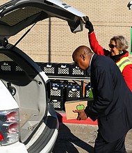 Commissioner Rodney Ellis loads nonperishable food into a vehicle at Worthing High School during the Holiday Food Boxes giveaway that Precinct One hosted in partnership with Houston Food Bank.
