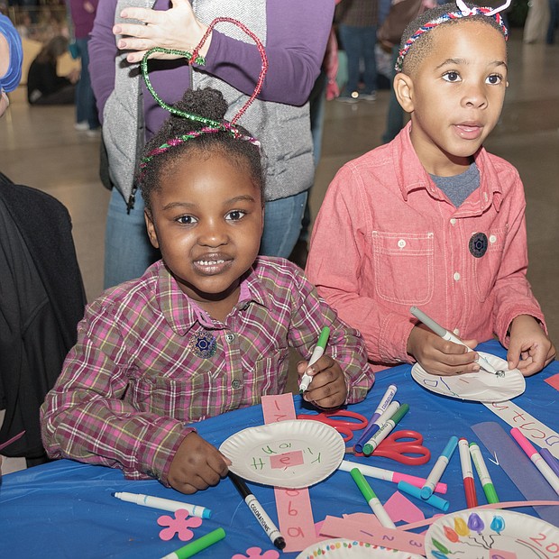 Ringing in the new year: Confetti rains down on 2,500 youngsters and their families gathered at the Science Museum of Virginia to ring in 2019 early — at noon on Monday. Youngsters, including Aleyah Michael, 4, left, and Brycen Woodson, 5, made wearable decorations for the “Noon Year’s Eve” celebration, which featured a giant party ball, music, countdown, noisemakers and a parade. Youngsters also could sign a huge banner with their resolutions for 2019. (Photo by Ava Reaves)