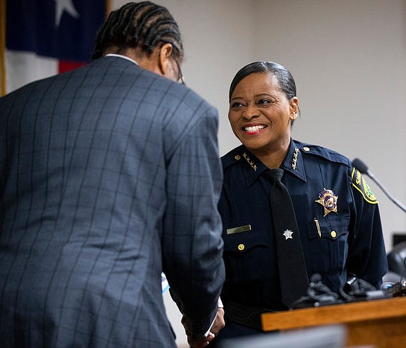 Dallas County Commissioner John Wiley Price shakes hands with Sheriff Marian Brown after swearing her in as sheriff.