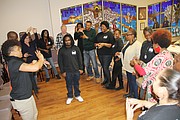 Spensean Singletary, center, a trainee with the program, gets feedback from the group during the daily opening session to build confidence and comfort.