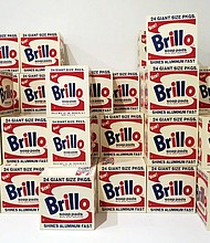 Andy Warhol’s “Brillo Boxes” on display at the Whitney Museum. Each box contains the OU kosher symbol, shown above, in the bottom left corner above the word “Shines.”