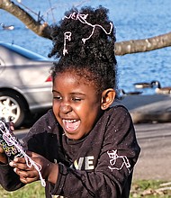 Warming up to winter: Chelsea Garba, 5, gets carried away with a spray can of Goofy String while playing with her dad, Makka Garba, by Fountain Lake in Byrd Park last Saturday, when the day was sunny and temperatures hovered near 60 degrees. What a change this weekend will bring, when high temperatures will be in the 30s, with snow forecast for Sunday. (Sandra Sellars/Richmond Free Press)