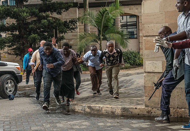 People run for cover after being rescued from the Dusit hotel.