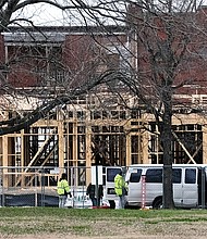 Workers are moving forward to create a $33 million apartment complex on a 2½-acre block in Jackson Ward, despite recent weather challenges. This view from 2nd and Duval streets shows the wooden framework of the 146 new apartments under construction on the site. (Sandra Sellars/Richmond Free Press)