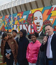 Happy 90th Birthday, Dr. King! Richmond Schools Superintendent Jason Kamras, right, speaks at the dedication Tuesday of a new mural honoring Dr. Martin Luther King Jr. that is located on the entryway to the Martin Luther King Jr. Bridge and adjacent to the Martin Luther King Jr. Pre-School Learning Center at 900 Mosby St. in the East End. The dedication was held on what would have been Dr. King’s 90th birthday. It is the second King mural on the site done by U.N.I.T.Y. Street Project; the first was completed in July. Muralists Sir James Thornhill and Hamilton Glass joined in the dedication ceremony, along with students from Martin Luther King Jr. Middle School who worked on the project. (Clement Britt)