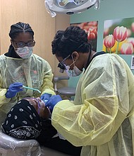 Dr. Christina Byerson, right, chief dental officer for the Capital Area Health Network, attends to a patient with dental assistant Courtney Satterwhite at last Friday’s free extraction clinic in Henrico County.