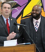 Gov. Ralph S. Northam, left, surprises Richmond teacher Rodney A. Robinson Wednesday by announcing his selection as a finalist for the National Teacher of the Year. Location: Virgie Binford Education Center at the Richmond Juvenile Detention Center, where Mr. Robinson teaches history and social studies.