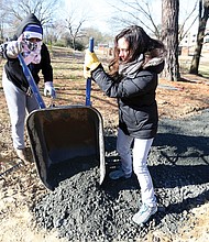 Rachel Motley, left, and Erin Almquist of Richmond pitch in to care for a biking and walking trail at Bellemeade Park in South Side on Monday as part of the City of Richmond’s “In Pursuit of the Dream” events.