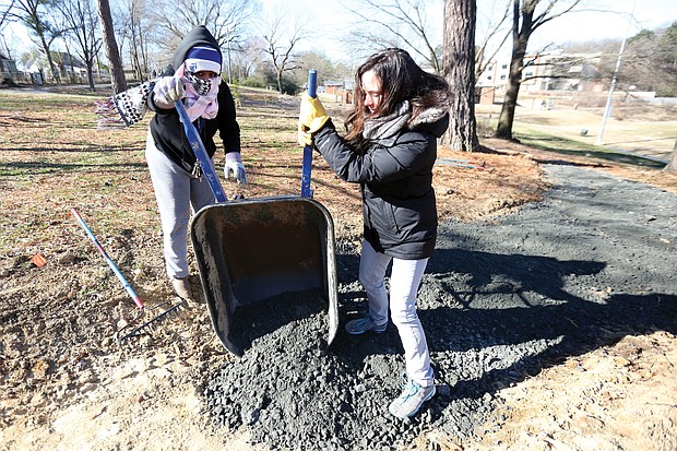 Rachel Motley, left, and Erin Almquist of Richmond pitch in to care for a biking and walking trail at Bellemeade Park in South Side on Monday as part of the City of Richmond’s “In Pursuit of the Dream” events.