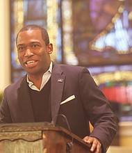 A participant holds a program as Mayor Levar M. Stoney speaks at St. Elizabeth’s Catholic Church to launch the city’s King Day volunteer activities.