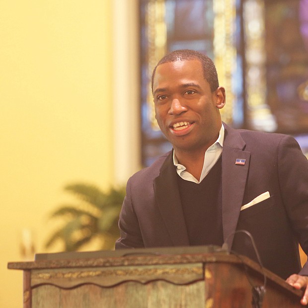 A participant holds a program as Mayor Levar M. Stoney speaks at St. Elizabeth’s Catholic Church to launch the city’s King Day volunteer activities.