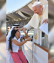 A little girl evaded tight police security inside Abu Dhabi's city stadium and ran to Pope Francis to deliver him a letter.