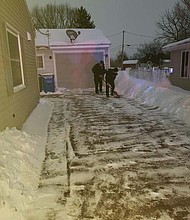 Iowa firefighters who were called to a home delivery shovel snow from the new parents' driveway.