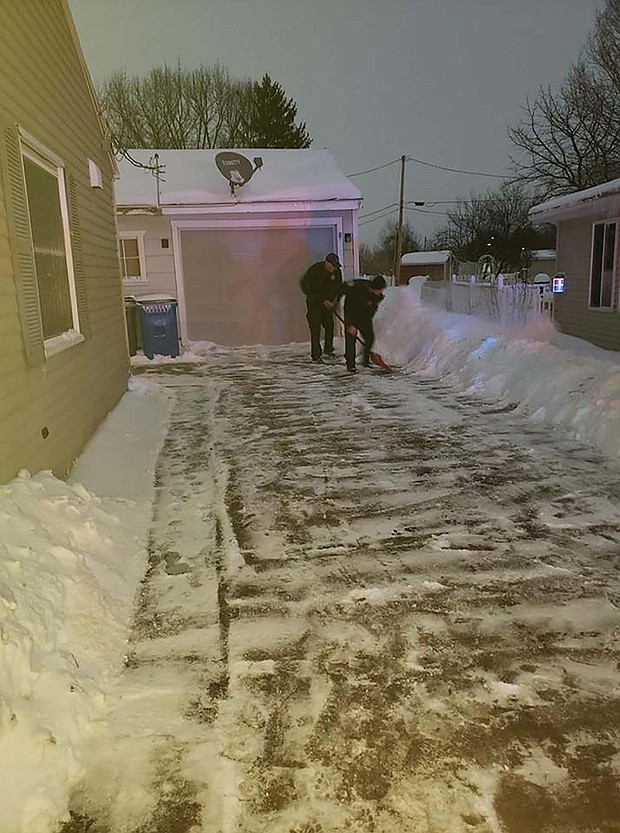 Iowa firefighters who were called to a home delivery shovel snow from the new parents' driveway.
