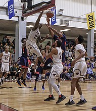 Virginia Union University and Virginia State University players go airborne under the basket in the hard-fought game last Saturday ad Barco-Sevens Hall.