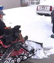 Iraq war veteran and teen next door partner up to remove neighborhood snow.