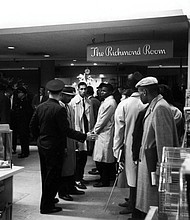 Richmond Police try to move Virginia Union University students out of The Richmond Room restaurant in Thalhimer’s department store in Downtown where they refused to leave, protesting the whites-only policy for service. Dr. A.J. Franklin is the student at center wearing the raincoat that is slightly open.