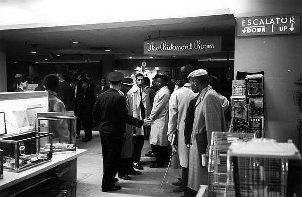 Richmond Police try to move Virginia Union University students out of The Richmond Room restaurant in Thalhimer’s department store in Downtown where they refused to leave, protesting the whites-only policy for service. Dr. A.J. Franklin is the student at center wearing the raincoat that is slightly open.