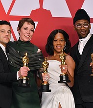 Winners of the top acting awards pose for a photo in the press room following Sunday’s awards show. They are, from left, Rami Malek, best actor in a leading role for “Bohemian Rhapsody;” Olivia Colman, best actress in a leading role for “The Favourite;” Regina King, best supporting actress for “If Beale Street Could Talk;” and Mahershala Ali, best supporting actor for “Green Book.” Below, Hannah Beachler, left, and Jay Hart hold their Oscars high after winning the award for best production design for “Black Panther.”