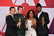 Winners of the top acting awards pose for a photo in the press room following Sunday’s awards show. They are, from left, Rami Malek, best actor in a leading role for “Bohemian Rhapsody;” Olivia Colman, best actress in a leading role for “The Favourite;” Regina King, best supporting actress for “If Beale Street Could Talk;” and Mahershala Ali, best supporting actor for “Green Book.” Below, Hannah Beachler, left, and Jay Hart hold their Oscars high after winning the award for best production design for “Black Panther.”