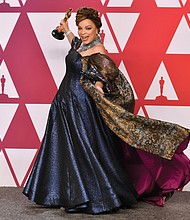 Ruth E. Carter prances in the press room with her Oscar for best costume design for the blockbuster hit “Black Panther.” She is the first African-American to win in that category.