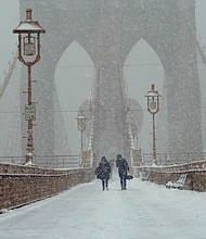 People are seen walking around Brooklyn bridge during a snowy day in New York City.

CREDIT: Ryan Rahman/SOPA Images/Lightrocket/Getty Images