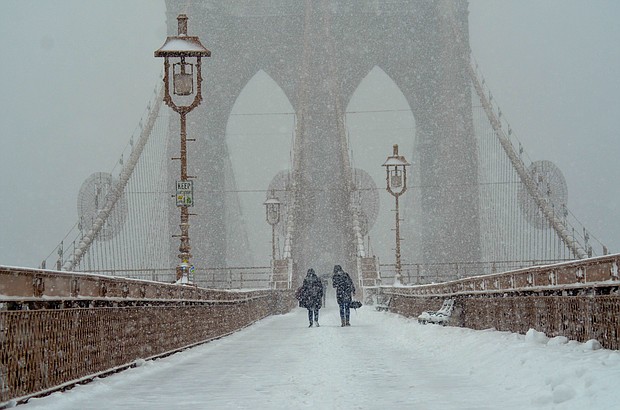 People are seen walking around Brooklyn bridge during a snowy day in New York City.

CREDIT: Ryan Rahman/SOPA Images/Lightrocket/Getty Images