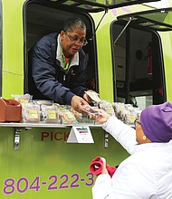‘Mobile Soul Sunday’':Teresa Rogers leans out of the window of her food truck business, Sweet Temptations by Teresa, to sell a sweet treat to Evangeline Wood of Ashland on Sunday on Hull Street. Ms. Rogers’ food truck was among 15 in South Side for “Mobile Soul Sunday,” the kickoff of the 2019 Richmond Black Restaurant Week Experience. The event, which runs through Sunday, March 10, highlights Richmond’s black-owned restaurants, food truck and cart operators, caterers and local chefs. (Regina H. Boone/Richmond Free Press)