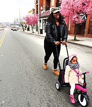 On a roll:
Shamika Robinson and her 18-month-old daughter, Londyn Bryant, head toward the delicious smells of food coming from a bevy of food trucks Sunday on Hull Street in South Side. The food truck rodeo kicked off the 2019 Richmond Black Restaurant Experience. Children’s games also were part of the festivities. (Regina H. Boone/Richmond Free Press)