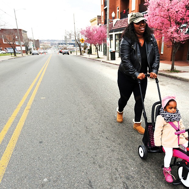 On a roll:
Shamika Robinson and her 18-month-old daughter, Londyn Bryant, head toward the delicious smells of food coming from a bevy of food trucks Sunday on Hull Street in South Side. The food truck rodeo kicked off the 2019 Richmond Black Restaurant Experience. Children’s games also were part of the festivities. (Regina H. Boone/Richmond Free Press)