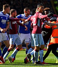 A fan is wrestled to the ground by a steward after punching Aston Villa's Jack Grealish.